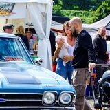 Ein Pärchen schaut sich einen alten Chevrolet auf der „Chrom & Flammen“-Show in Recklinghausen an
