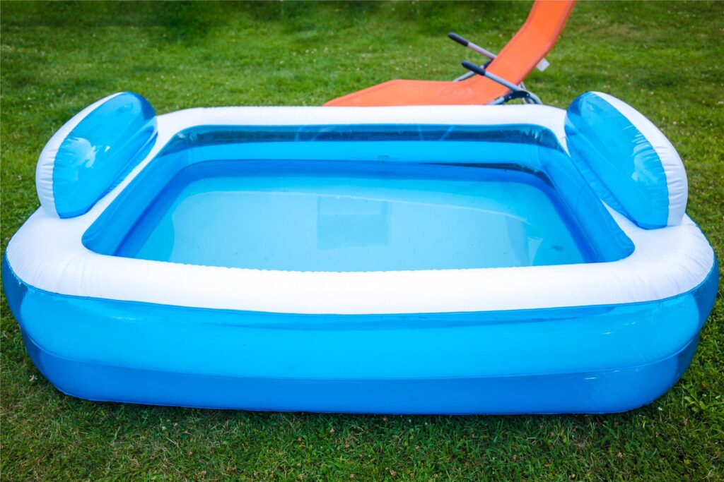 Mit Wasser befülltes Planschbecken auf einer Sommerwiese Mit Wasser befülltes Planschbecken auf einer Sommerwiese