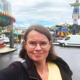 HA-Redakteurin steht auf dem Gelände der Cranger Kirmes zwischen verschiedenen Fahrgeschäften.