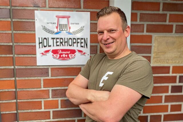 Markus Holterhoff aus Datteln steht vor dem Schild seiner Brauerei „Holterhopfen“.