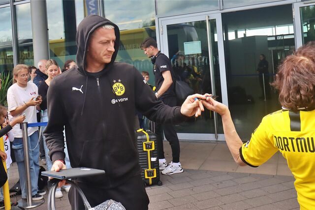 Marco Reus gibt einem Fan ein Autogramm.