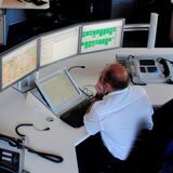 Ein Mann sitzt vor mehreren Bildschirmen