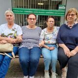 Vier Frauen sitzen auf einer Bank.
