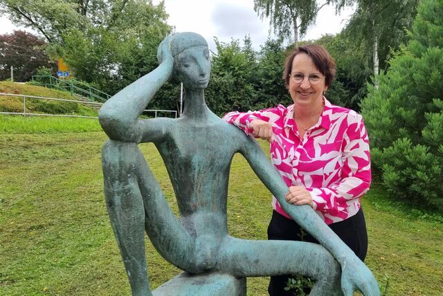 Eine Frau steht an einer Statue