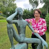 Eine Frau steht an einer Statue