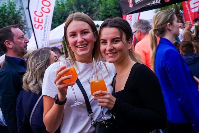Zwei Frauen mit Gläsern in den Händen stehen bei „Zu Gast in Recklinghausen 2023“ auf dem Rathausplatz
