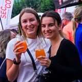 Zwei Frauen mit Gläsern in den Händen stehen bei „Zu Gast in Recklinghausen 2023“ auf dem Rathausplatz