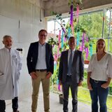 Drei Männer und eine Frau stehen in einem Rohbau.