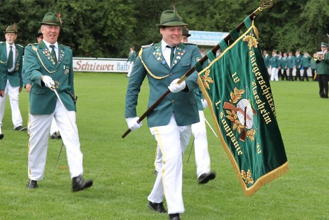 Mann in Schützenuniform trägt eine Fahne