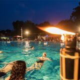 Im Parkbad Nord in Castrop-Rauxel schwimmen Menschen, während es bereits dunkel ist.