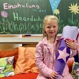 Die Erstklässlerin Josefine sitzt in Oer-Erkenschwick mit ihrer Schultüte auf einer Bank in der Haardschule.