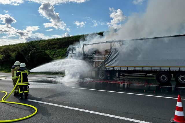 Zwei Feuerwehrleute löschen einen Lkw-Brand auf der A 2 Richtung Oberhausen kurz vor der Anschlussstelle Recklinghausen-Süd.