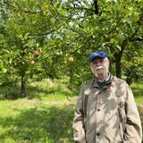 Ein Mann steht auf einer grünen Wiese in Herten vor Obstbäumen.