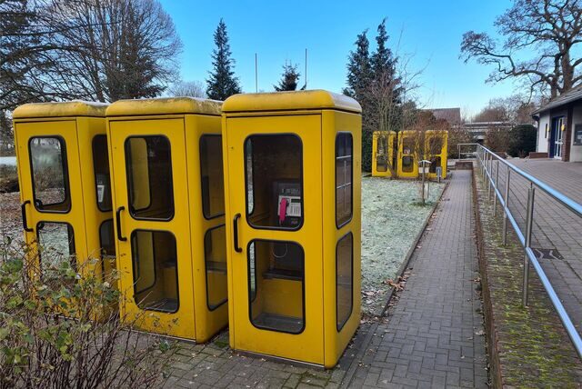 Sechs alte gelbe Telefonhäuschen im Meisenhof