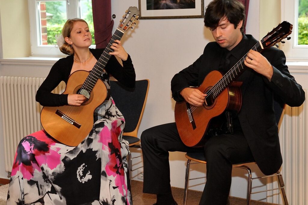 Zwei Menschen spielen Gitarre 