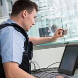 Ein Bundespolizist kontrolliert den Personalausweis einer Reisenden (Symbolfoto).