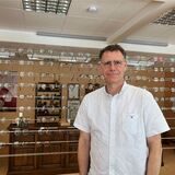 Peter Schanz vor ganz vielen Brillen in seinem Optiker-Geschäft.