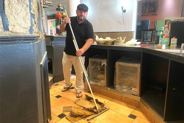 Silat Omirate steht mit einem Schrubber in der Küche und beseitigt die Wasserschäden im Restaurant „Maroush“ in Recklinghausen.