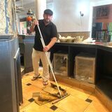 Silat Omirate steht mit einem Schrubber in der Küche und beseitigt die Wasserschäden im Restaurant „Maroush“ in Recklinghausen.