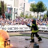 Ein Feuerwehrmann der Recklinghäuser Feuerwehr löscht zu Demonstrationszwecken einen Brand auf dem Rathausplatz.