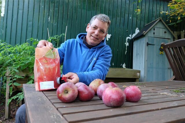 Stefan Wanske vom NABU Recklinghausen präsentiert einen Kanister mit Apfelsaft.