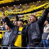 Zwei BVB-Fans halten einen Schal in die Luft.