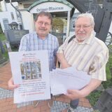 Mitglieder des Heimatvereins, wie hier Manfred Panse (links) und Wolfgang Dohte, machen Werbung für das Bleiglasfenster im Hirschkamp.