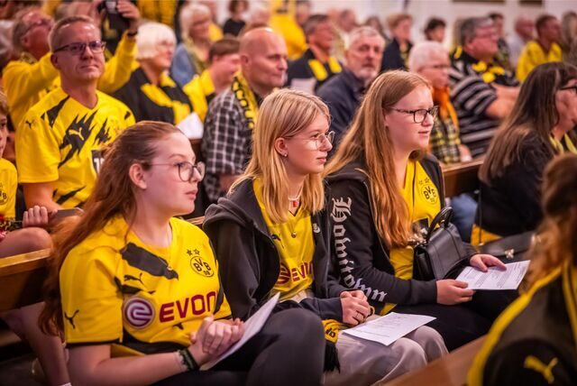 Drei weibliche BVB-Fans sitzen im Sonder-Gottesdienst zum Saisonstart in der Dreifaltigkeitskirche.