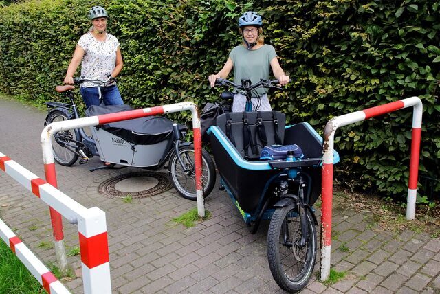 Zwei Frauen mit Lastenrädern wollen ein Hindernis passieren.