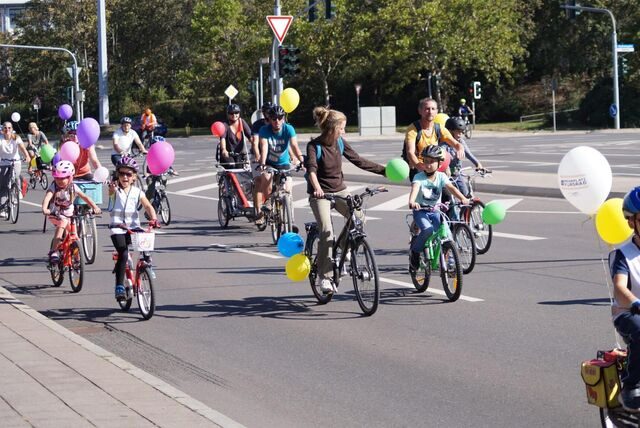 Kinder und Erwachsene bei Fahrraddemo „Kidical Mass“ mit Ballons auf der Straße