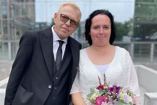 Dirk und Stephanie Grund haben in Dortmund geheiratet. Nach ihrer Trauung stehen sie auf dem Friedensplatz.