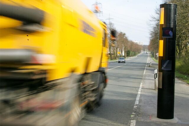 Eine Radarsäule am rechten Fahrbahnrand. Links fährt gerade ein Lkw an ihr vorbei.
