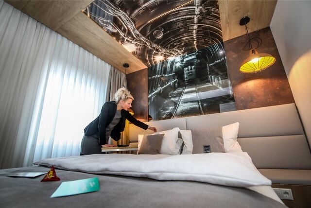 Eine Frau richtet im Hotel Esplanade in Dortmund ein Bett her.