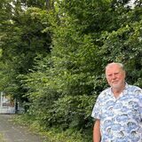 Klaus Jürgen Brinker steht vor der zugewucherten Bushaltestelle Vincennesstraße