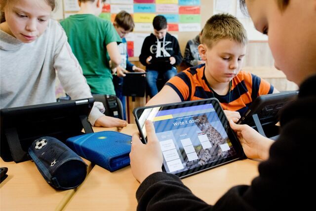 Schüler, die mit einem Ipad in einem Klassenzimmer lernen.