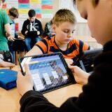 Schüler, die mit einem Ipad in einem Klassenzimmer lernen.
