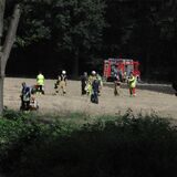 Feuerwehrmänner stehen auf einem Getreidefeld.