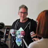 Lehrer Wolfgang Wittchow vor diversen Mikrofonen unterschiedlicher Medien.