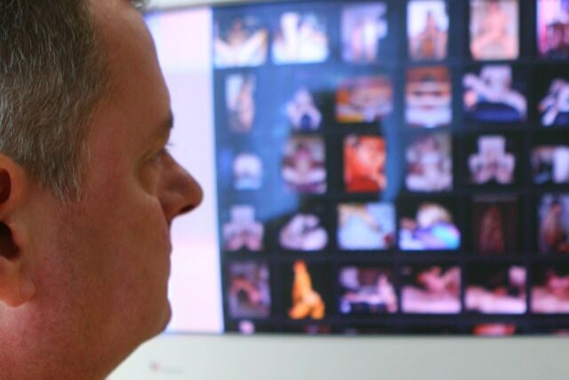 Ein Mann schaut auf einen Computerbildschirm, auf dem kleine Bilder zu sehen sind.