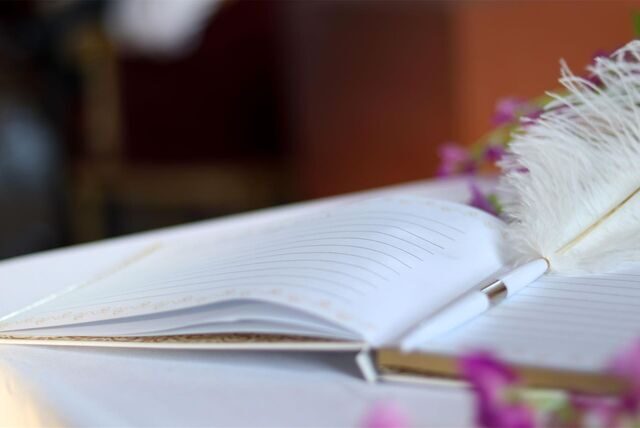 Ein Stift liegt auf einem Gästebuch einer Hochzeit.