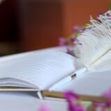 Ein Stift liegt auf einem Gästebuch einer Hochzeit.