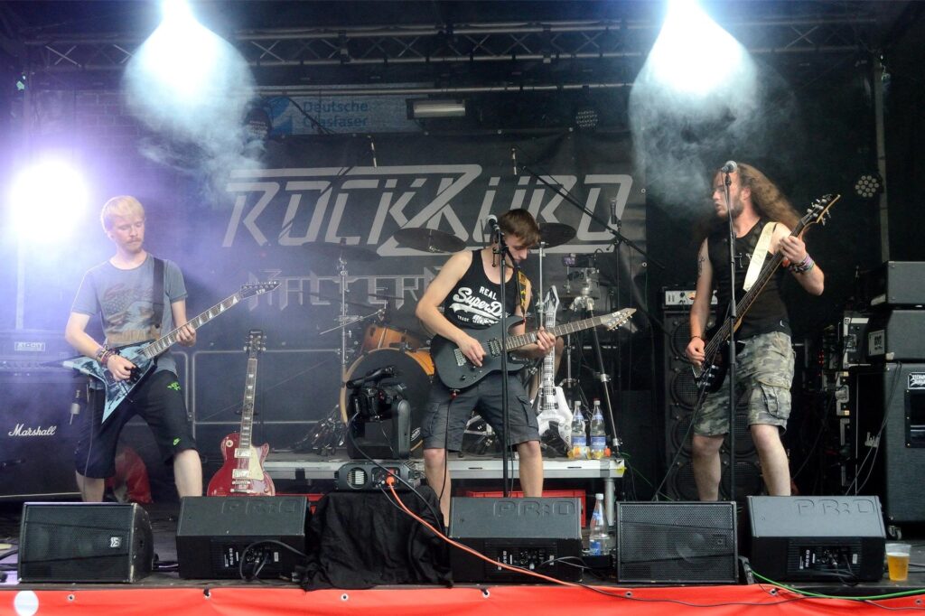 Eine Rockband steht auf der Bühne. Eine Rockband steht auf der Bühne.