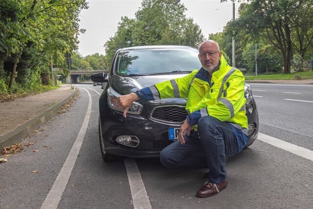Ralf Feldhaus vom Dattelner Ordnungsamt hockt vor einem falsch geparkten Auto. Sein rechter Daumen zeigt nach unten.