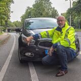 Ralf Feldhaus vom Dattelner Ordnungsamt hockt vor einem falsch geparkten Auto. Sein rechter Daumen zeigt nach unten.