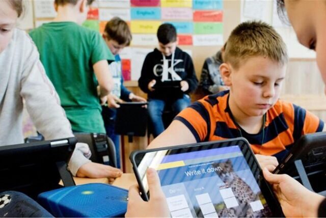 Schüler, die mit einem Ipad in einem Klassenzimmer lernen.