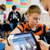Schüler, die mit einem Ipad in einem Klassenzimmer lernen.