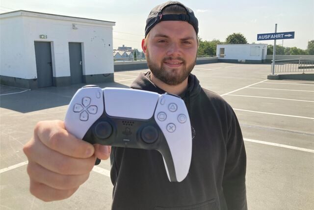 Schmiede-Mitarbeiter Jan Jacobi hält eine Playstation-Konsole in die Kamera.