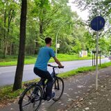 Ein Mann fährt Fahrrad auf einem Radweg.