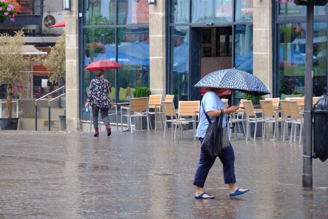Zwei Frauen laufen mit einem Schirm durch die Recklinghäuser Innenstadt.