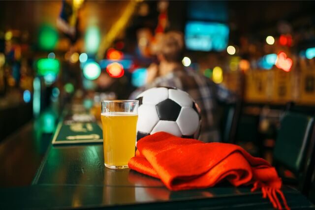 fußball schal und bierglas auf einer theke in einer bar